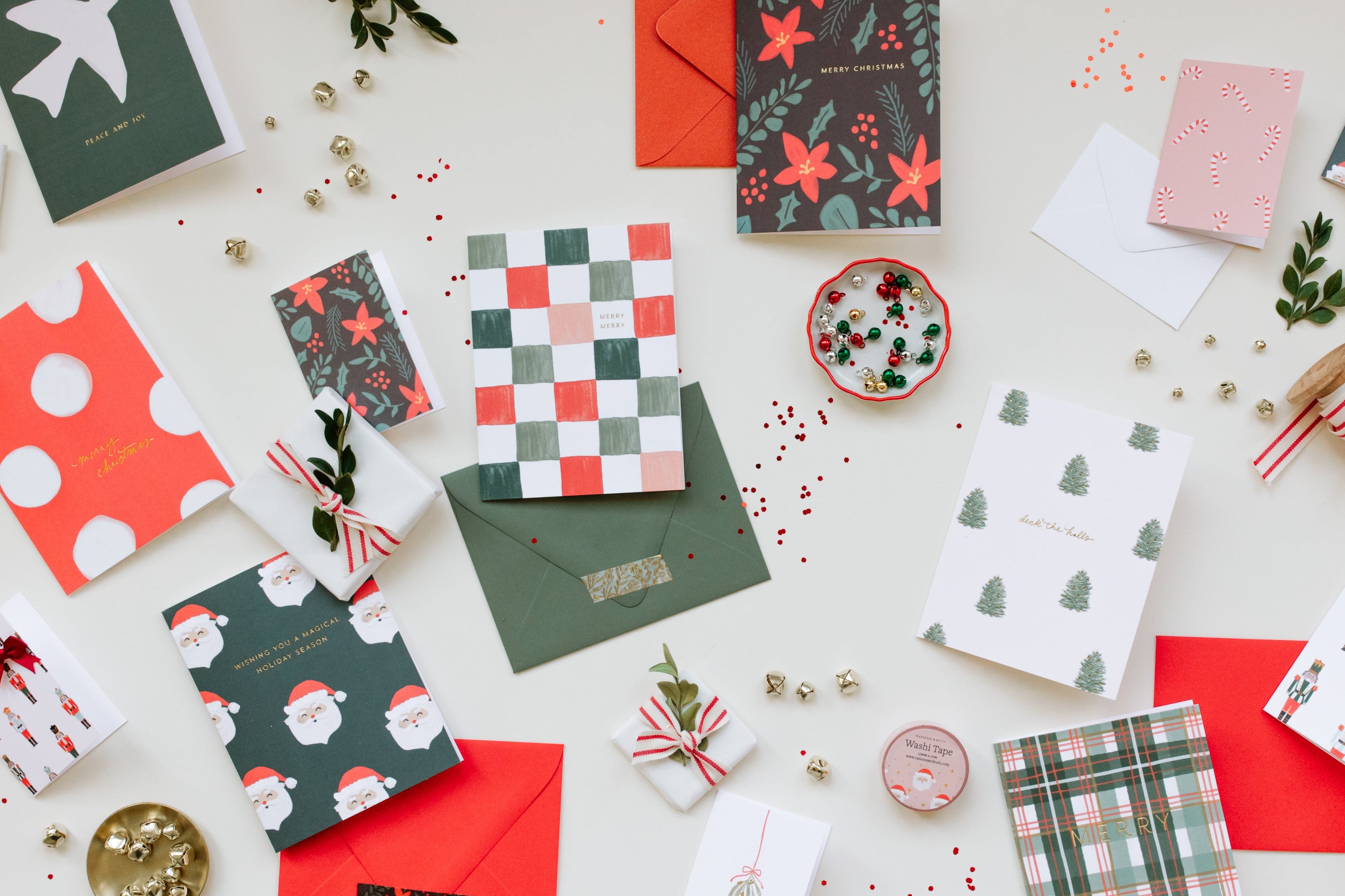 Collection of Christmas-themed cards and envelopes on a white surface.